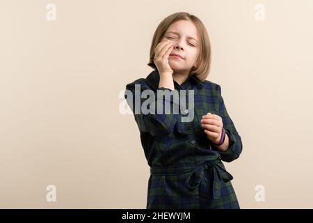 L'enfant a un mal de dents.Kid Little Girl 9s porter une robe-chemise à carreaux se sentant malade et stressé.Problème de santé.Concept de santé et de médecine.Espace pour le texte Banque D'Images