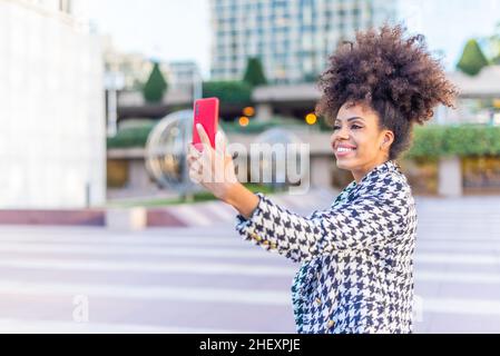 femme noire prenant un selfie souriant avec un téléphone portable Banque D'Images