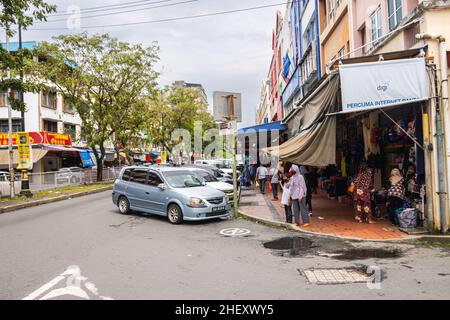 Sandakan, Malaisie - 06 janvier 2022 : paysage urbain de la ville de Bornéo.Maisons délabrées et vieilles voitures malaisiennes dans la rue.Deuxième plus grande ville de Sabah Banque D'Images