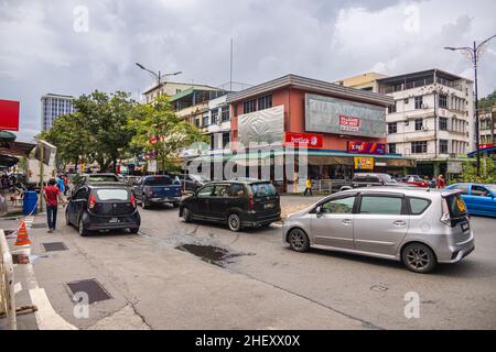 Sandakan, Malaisie - 06 janvier 2022 : paysage urbain de l'in Bornéo.Maisons délabrées et vieilles voitures malaisiennes dans la rue.Deuxième plus grande ville de Sabah a Banque D'Images