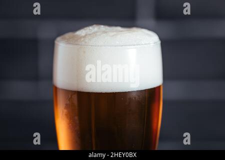 Verre de bière avec mousse et quatre en-cas différents Banque D'Images