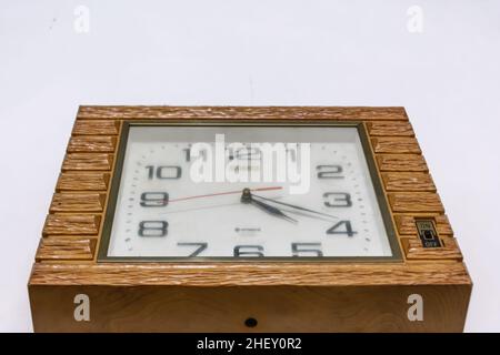 horloge en bois brun vintage et rétro accrochée au mur blanc Banque D'Images