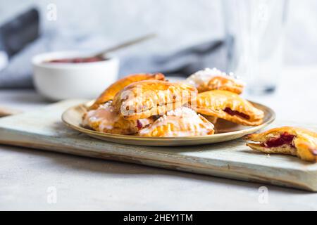 Tartes pop à coeur de fraise, prises depuis le haut sur un fond en béton.Pâtisserie savoureuse au grille-pain Banque D'Images