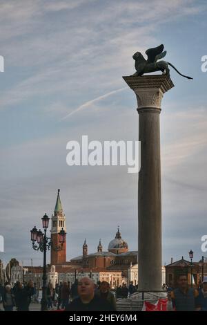 Colonne portant un symbole de lion ailé de bronze de la saint-Marc évangéliste, Saint patron de la ville de Venise.Église Saint george en arrière-plan Banque D'Images