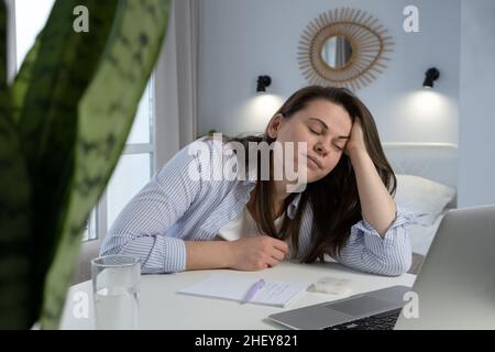 Une femme fatiguée dort sur son lieu de travail.Concept professionnel de l'épuisement, de la fatigue et des troubles du sommeil Banque D'Images