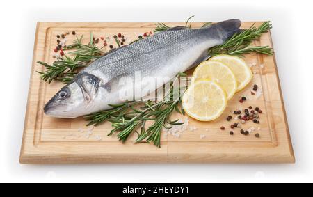 Seabass frais non cuits avec citron et romarin sur panneau de bois sur fond blanc avec passe-cheveux Banque D'Images