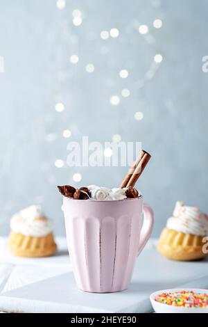 Une tasse de cacao avec des marmelaws et des muffins à la vanille avec de la crème au fromage à la crème.Copier l'espace. Banque D'Images