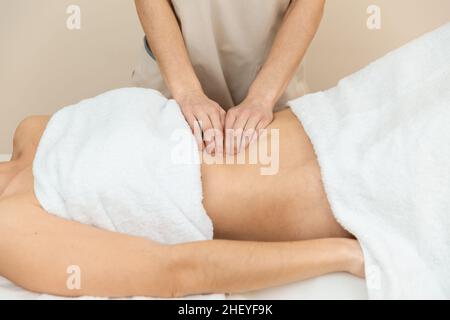 Un thérapeute qui donne un massage abdominal chez une patiente Banque D'Images