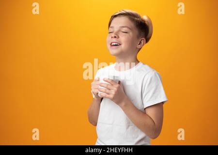 L'enfant boit du cacao chaud sur fond jaune Banque D'Images