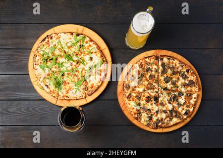 Vue de dessus d'une table avec deux pizzas et un verre de vin et de bière Banque D'Images
