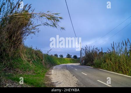 Ancienne route rurale illuminée dans la soirée nuageux, Torres Vedras, Portugal Banque D'Images