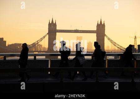 Les employés de la ville traversent le London Bridge tandis que le soleil se lève vers l'est lorsqu'ils se rendent dans la City de Londres le matin d'hivers clairs, City of London, Royaume-Uni, 13th janvier 2022.Londres, Angleterre, Royaume-Uni crédit: Jeff Gilbert/Alay Live News Banque D'Images