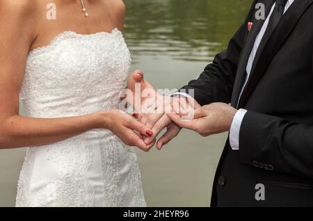 le couple de mariage est attachant la loyauté à vie dans le parc lors de la cérémonie de mariage Banque D'Images