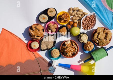 Papier peint Makar sankranti avec des plats spéciaux du festival Sankranti servis et mangés comme le chikki de Peanut, laddu de tilgul, jus de baati, les fruits du mandrin, les arachides, Banque D'Images