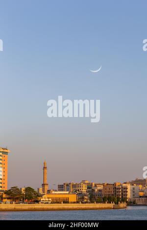 Horizon de Deira, Dubaï au coucher du soleil avec Dubai Creek, mosquée minaret et croissant de lune dans le ciel, Émirats arabes Unis. Banque D'Images