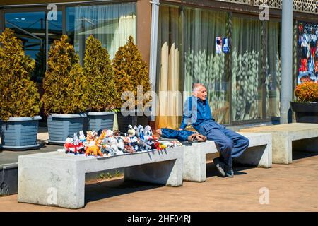Un vieil homme vend des jouets mous sur un banc de rue.Batumi, Géorgie - 03.28.2021 Banque D'Images