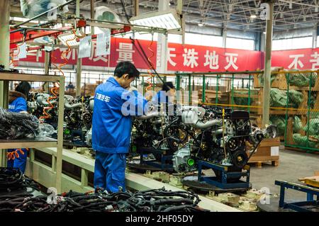 Moteurs en attente d'être installés dans les voitures Lifan 520 sur une chaîne de production à Chongqing, en Chine Banque D'Images