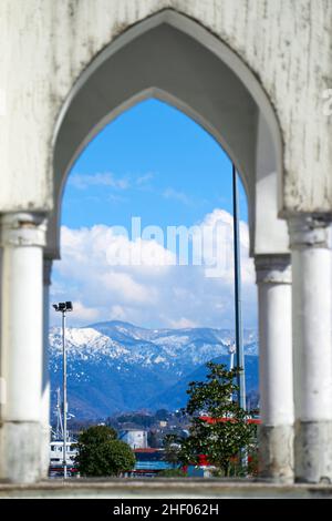 Vue sur les montagnes enneigées à travers l'arche du bâtiment. Banque D'Images