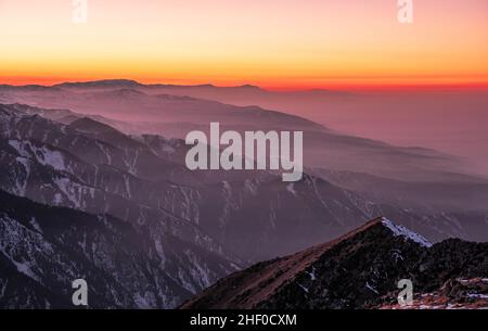 Atmosphère magique d'un coucher de soleil dans les montagnes ; ciel de coucher de soleil sur des crêtes de montagne enneigées Banque D'Images