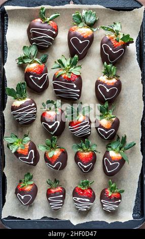Vue de dessus des fraises enrobées de chocolat sur papier parchemin. Banque D'Images
