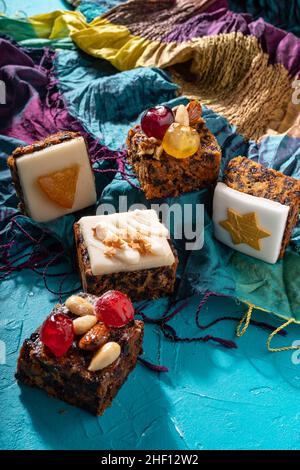 Des puddings de Noël riches et sucrés, remplis de fruits secs, de noix et d'épices sur fond turquoise de l'est Banque D'Images