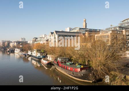 Péniche aménagée sur la Tamise avec le nouveau projet de logement de Kew Bridge Road au premier plan et le domaine de Brentford Towers à l'arrière Banque D'Images