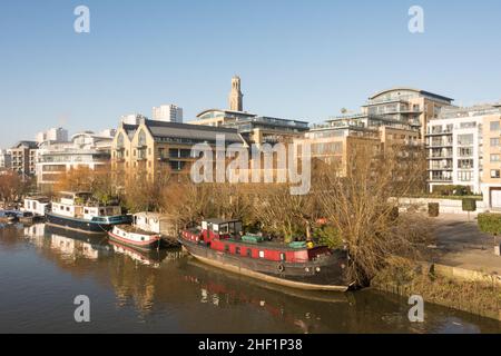 Péniche aménagée sur la Tamise avec le nouveau projet de logement de Kew Bridge Road au premier plan et le domaine de Brentford Towers à l'arrière Banque D'Images