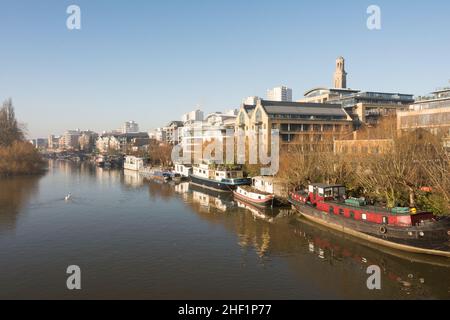 Péniche aménagée sur la Tamise avec le nouveau projet de logement de Kew Bridge Road au premier plan et le domaine de Brentford Towers à l'arrière Banque D'Images