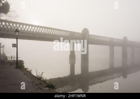 Le Kew Railway Bridge de W. R. Galbraith est entouré d'un épais brouillard à Strand-on-the-Green, Chiswick, Londres, Angleterre, Royaume-Uni Banque D'Images