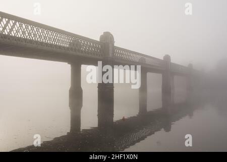 Le Kew Railway Bridge de W. R. Galbraith est entouré d'un épais brouillard à Strand-on-the-Green, Chiswick, Londres, Angleterre, Royaume-Uni Banque D'Images