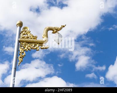La statue de serpent d'or était ornée sur un poteau lumineux de rue dans le temple thaïlandais, vue de face avec l'espace de copie. Banque D'Images