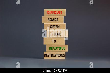 Symbole de motivation.Des blocs avec des mots routes difficiles mènent souvent à de belles destinations.Belle table grise, fond gris, espace de copie.Buline Banque D'Images