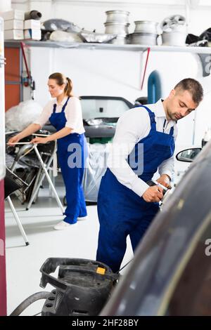 Homme ouvrier meulant voiture de corps Banque D'Images