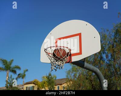 Vue à angle bas du ballon de basket-ball passant par le filet Banque D'Images