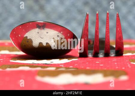 Pudding de Noël avec le visage reflété dans une cuillère et une fourchette Banque D'Images