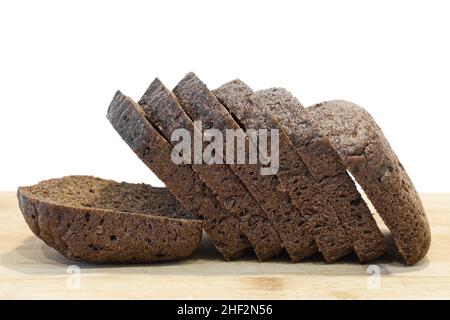 Tranches de pain de seigle sur panneau de bois isolé sur fond blanc.Pain de seigle cuit. Banque D'Images