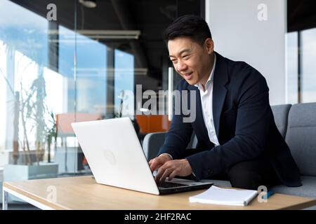 Un bon patron d'homme d'affaires se réjouit de regarder l'appareil photo et de sourire, travaillant dans un bureau moderne Banque D'Images