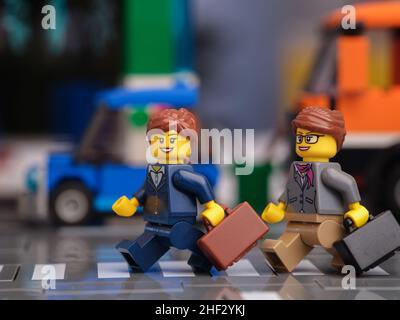 Tambov, Fédération de Russie - le 13 janvier 2022 deux femmes de la Lego qui tiennent des valises traversant une route fréquentée à l'aide d'un cros piétonnier Banque D'Images