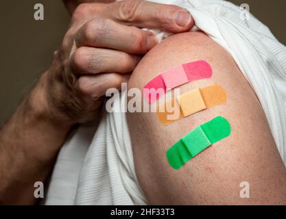 Manchon d'homme caucasien âgé pour montrer le troisième vaccin de rappel contre le coronavirus dans l'épaule.Concept avec trois bandages séparés pour les prises de vue Banque D'Images