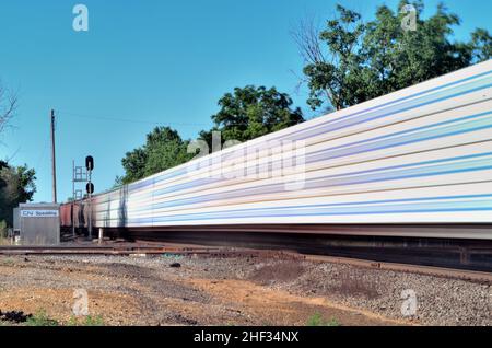 Elgin, Illinois, États-Unis. Un train de marchandises, brouillé par son mouvement, passant par Spaulding Junction. Banque D'Images