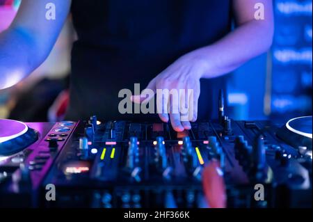 Gros plan vue de face des mains du DJ contrôlant une table de musique dans une discothèque.Photo de haute qualité Banque D'Images