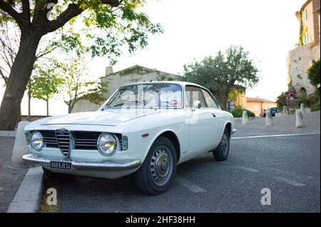 Un blanc 1600 Giulia Sprint GT Veloce garé dans la rue dans le pittoresque village français perché du Castellet. Banque D'Images