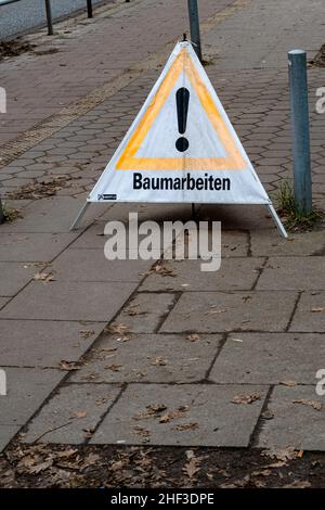 trottoir avec un panneau d'avertissement qui dit arbre de travail en allemand Banque D'Images