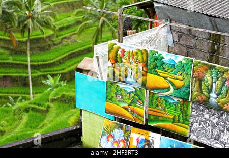 Peintures balinaises en vente avec champs de riz en terrasse à l'arrière-plan à Tegallalang à Ubud, Bali, Indonésie Banque D'Images