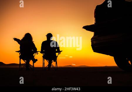 Excursion sur route au coucher du soleil dans le désert.Couple appréciant les couleurs chaudes et orange-rouge du désert pendant le coucher du soleil.Mojave Desert California, États-Unis. Banque D'Images