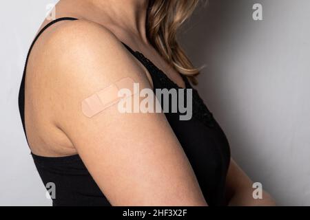 Vaccination sur l'épaule d'une femme.Patch médical sur la peau. Banque D'Images