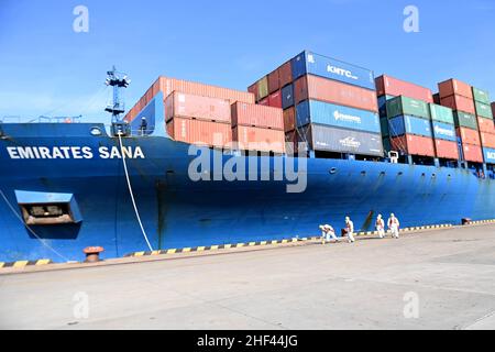 QINGDAO, CHINE - le 14 JANVIER 2022 - les Dockers attendent de fixer les câbles et de désinfecter les câbles aux navires de fret au quai entièrement automatisé du port de Qianwan Banque D'Images