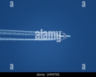 Gros plan téléobjectif d'un Boeing 747 KLM en direction d'Amsterdam à haute altitude avec contrailles. Banque D'Images