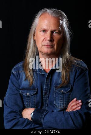 portrait d'un homme âgé avec de longs cheveux gris en studio sur fond noir Banque D'Images