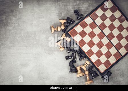Échiquier et pièces d'échecs dispersées, vue du dessus. Banque D'Images